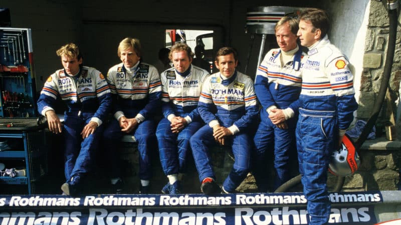 1984 Porsche sports car drivers sitting in pit garage