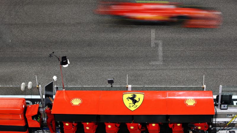 Blurred Ferrari goes past the Ferrari F1 pitwall