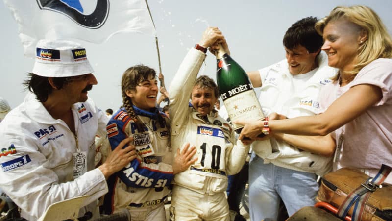 Gaston Rahier celebrates winning the 1984 Paris Dakar with a large bottle of champagne