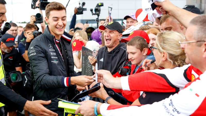 George Russell signs autographs for fans at Silverstone ahead of the 2022 British Grand Prix