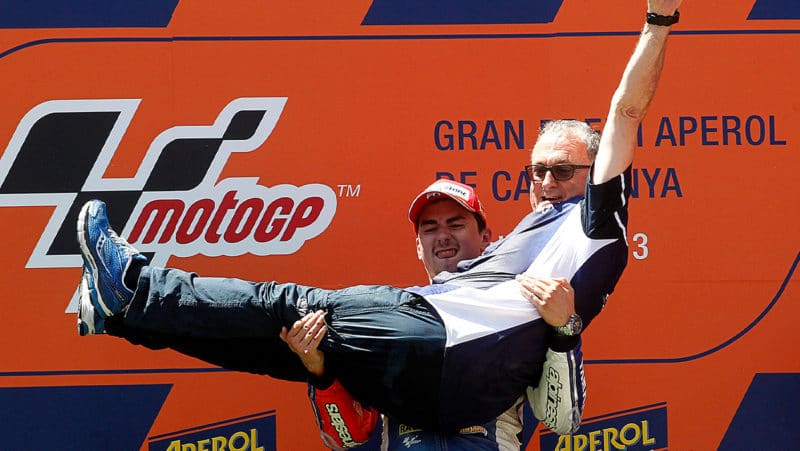 Jorge Lorenzo carries ramon Forcada on the podium after the 2013 MotoGP Catalan GP