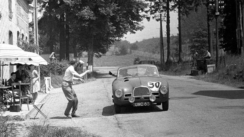 Lance Macklin reaches out of his car to grab a beer at the 1949 Spa 24 Hours