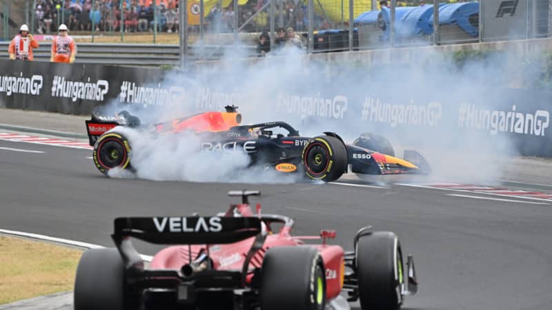 Max Verstappen spins ahead of Charles Leclerc in a cloud of tyre smoke at the 2022 Hungarian Grand Prix