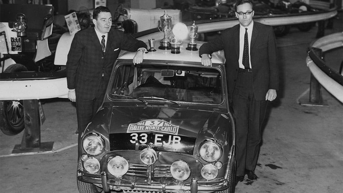 Northern Irish rally driver Paddy Hopkirk (left) and co-driver Henry Liddon (1932 - 1987) with the Mini Cooper S, in which they recently won the Monte Carlo Rally, at the Racing Car Show at Olympia, London, 27th January 1964. (Photo by Keystone/Hulton Archive/Getty Images)