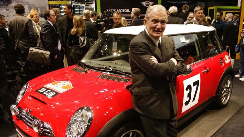 UNITED STATES - FEBRUARY 04: Paddy Hopkirk, who won the 1964 Monte Carlo Rally in a Mini, stands next to a next to a newly unveiled limited edition Mini Cooper S at the Chicago Auto Show February 4, 2004 in Chicago, Illinois. Purchasers of the car will receive the removable magnet racing numbers shown and the car will be autographed by Hopkirk. (Photo by John Zich/Bloomberg via Getty Images)