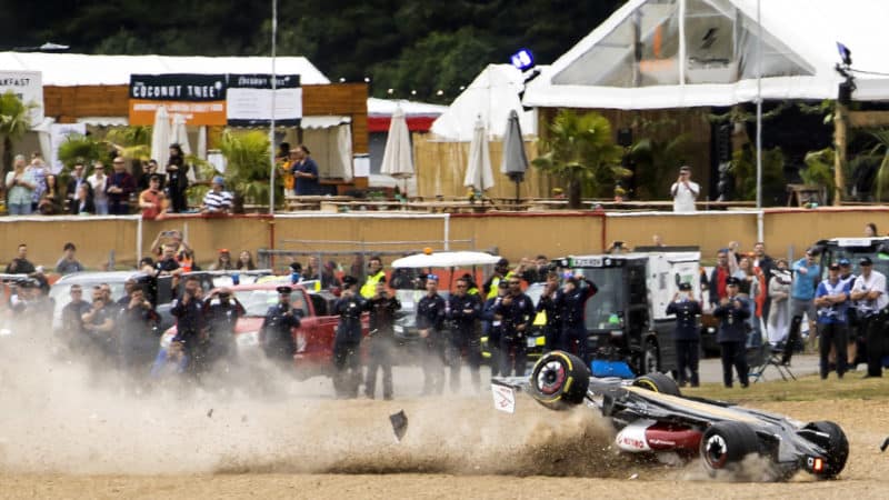 Upside down Alfa Romeo of Zhou Guanyu slides through gravel at the 2022 British Grand Prix