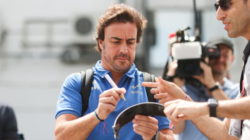 Fernando Alonso signs a helmet visor for a fan at the 2022 Hungarian Grand Prix