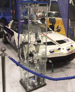 Fiat X1-9 racing car next to trophy cabinet