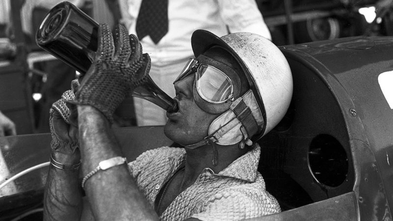 Stirling Moss drinking water during a pit stop