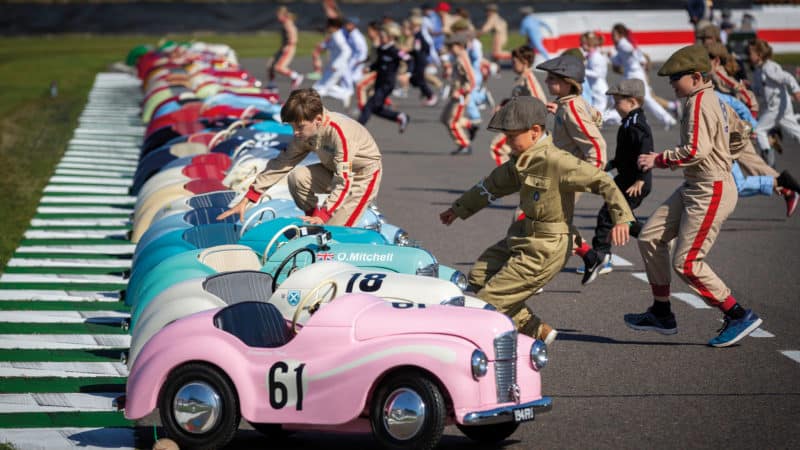 Young racers dash to Austin J40s at the Goodwood Revival