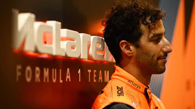 Daniel-Ricciardo-leans-against-a-McLaren-F1-sign-at-the-2022-SIngapore-GP