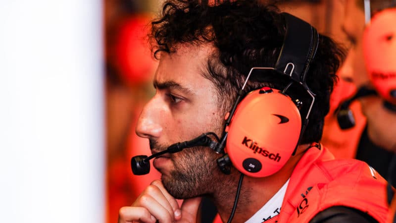 Daniel Ricciardo wearing headphones in the McLaren F1 pit garage