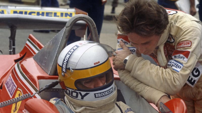 Gilles Villeneuve leans in to the Ferrari cockpit of Jody Schecketer in the 1979 British Grand Prix