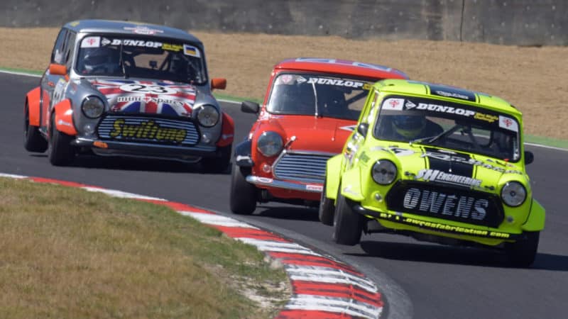 Mini of Endaf Owens with its wheel in the air as he is chased down by rivals in the mini Miglia at Brands Hatch 2022
