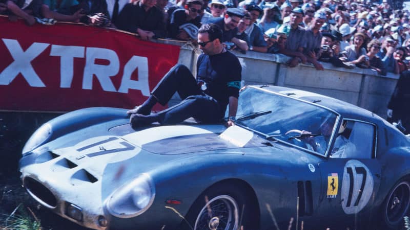 FIA official Filippo Theodoli sits atop a 250 GTO at Le Mans in 1962