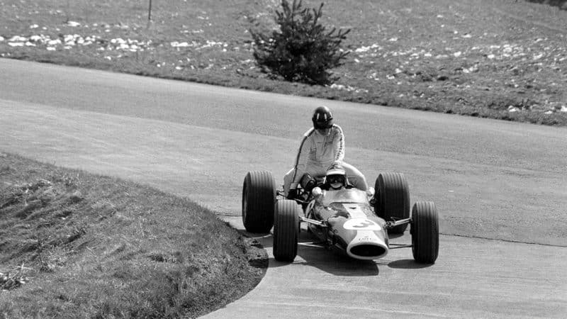 lark takes team-mate Graham Hill back to the pits