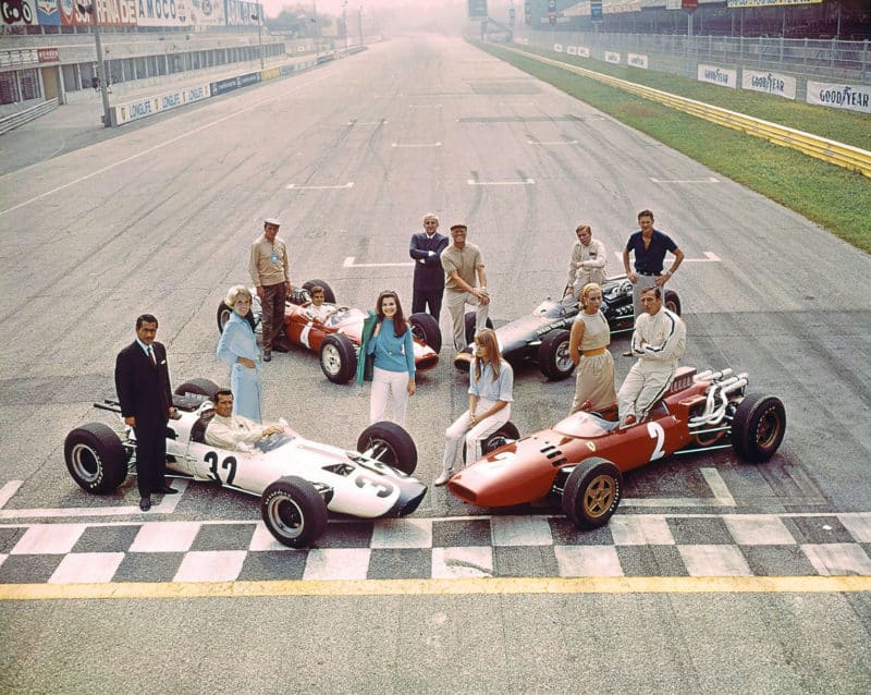 The cast of Grand Prix assemble for a photoshoot. Star James Garner sits aboard car 32. But it was so nearly Steve McQueen who landed the role of Pete Aron