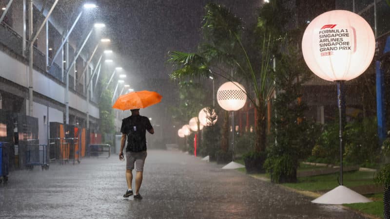 Man walks through F1 paddock in the rain at the 2022 Singapore Grand Prix