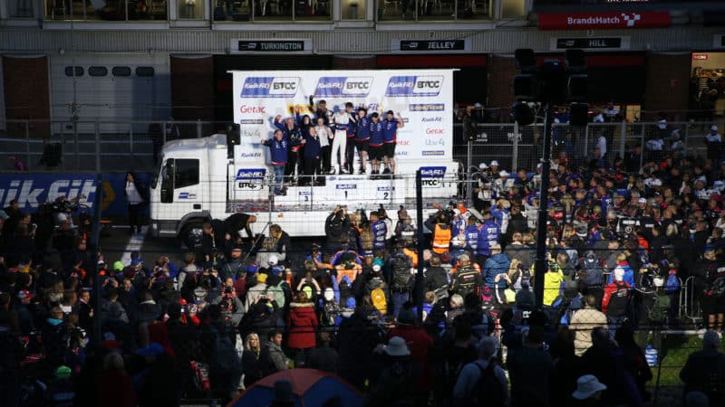 Tom Ingram celebrates becoming BTCC champion on the podium with his team