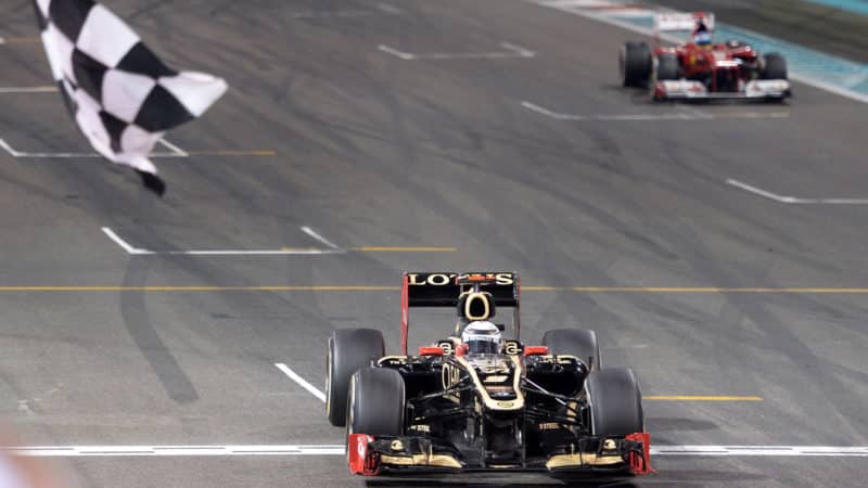 Chequered flag waves as Kimi Raikkonen crosses the line to win the 2012 Abu Dhabi Grand Prix