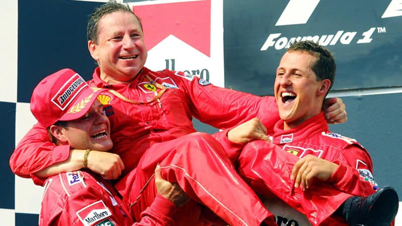 Michael Schumacher and rubens Barrichello lift Jean Todt onto their shoulders on podium