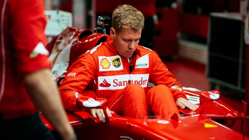 Sebastian Vettel gets into a ferrari F1 car cockpit for his first test in 2014