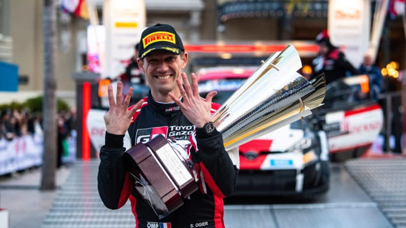 Sebastien Ogier holds nine fingers up while holding trophy for his ninth monte Carlo Rally WRC win