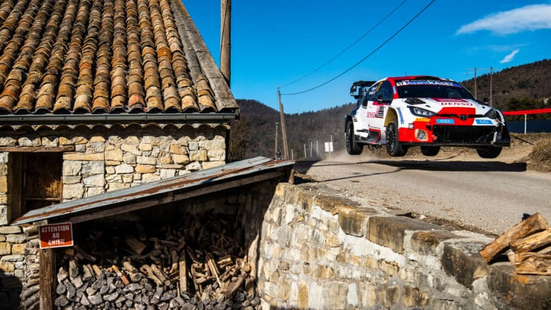 Toyota of Sebastian Ogier leaps over a jump past a house in the 2023 Monte Carlo Rally