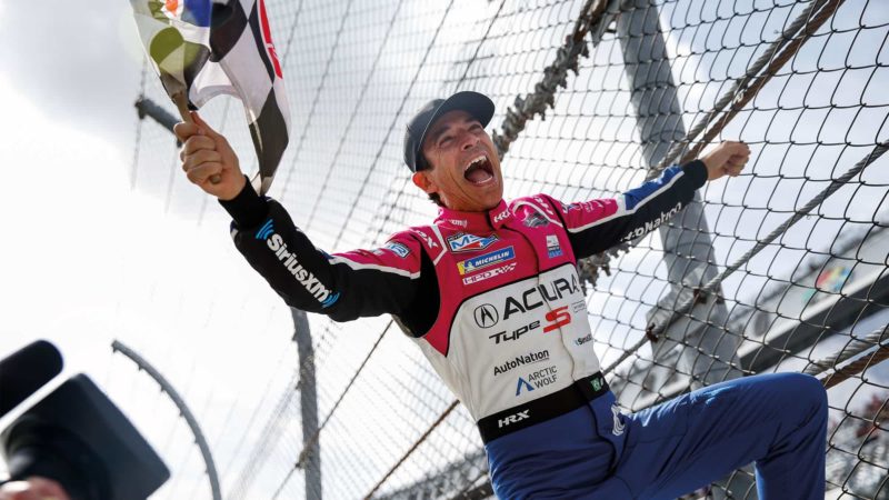 Castroneves celebrating on the fence