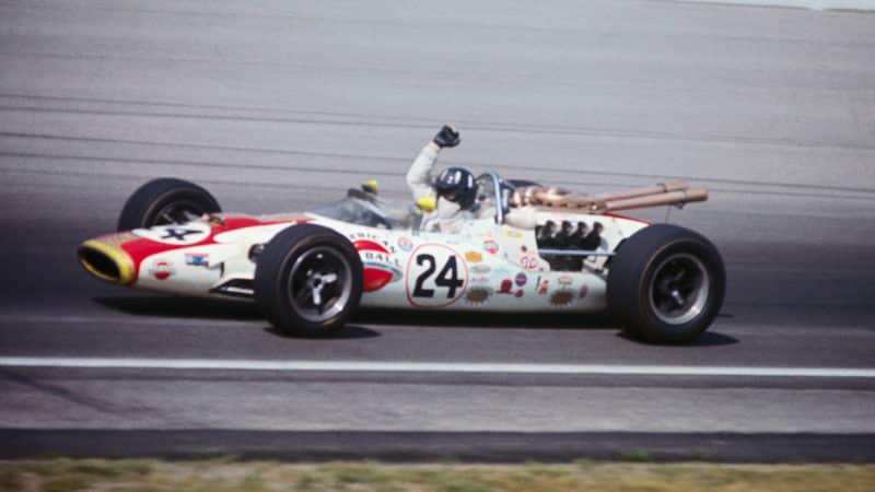 Graham Hill raises his arm in car after winning the Indy 500