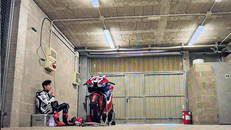 Marc Marquez sits in garage with motorbike
