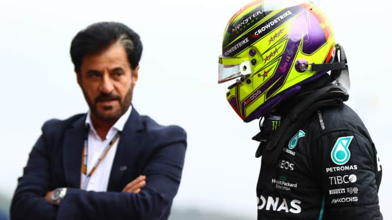 Mohammed Ben Sulayem looks across at Lewis Hamilton