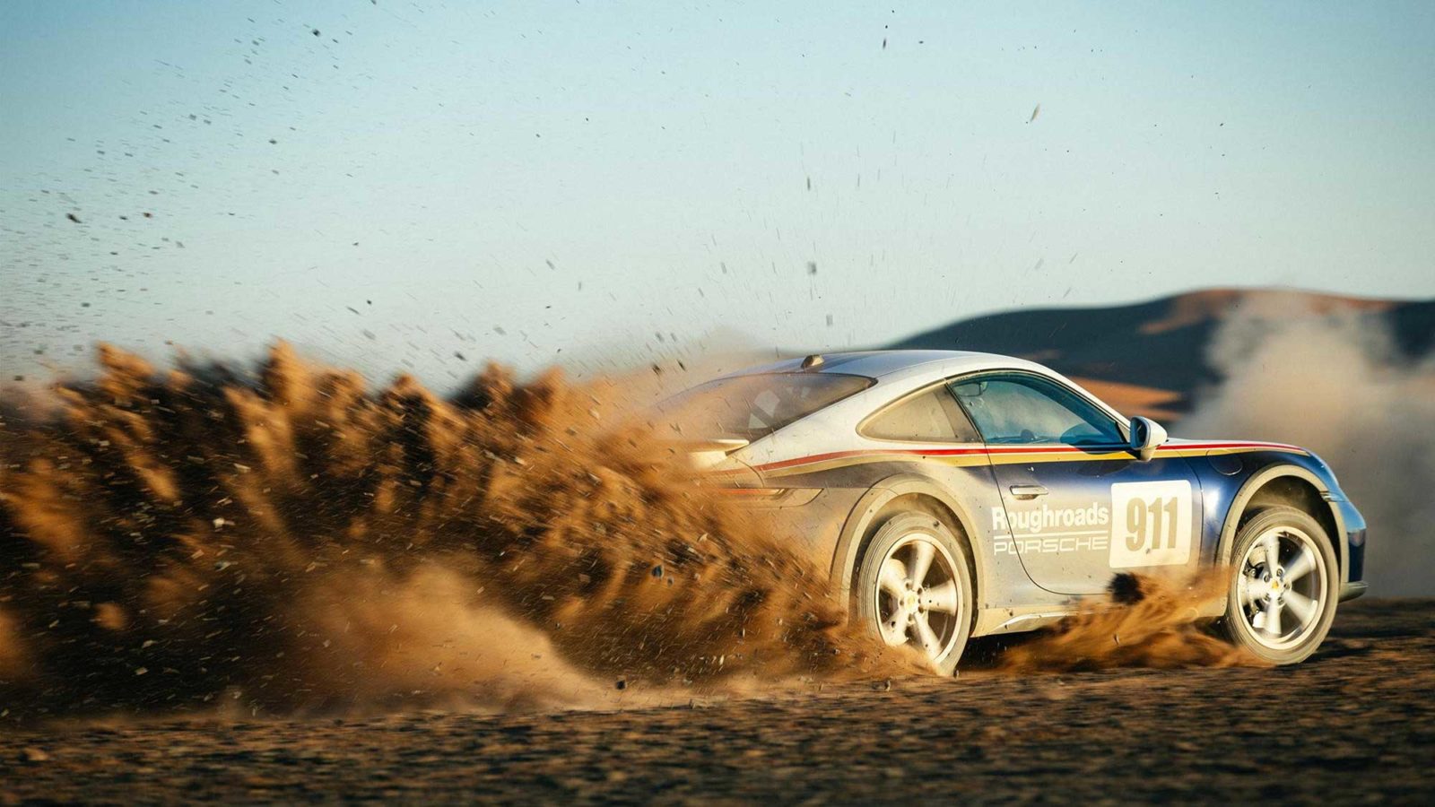 Porsche 911 kicking up dust in Dakar