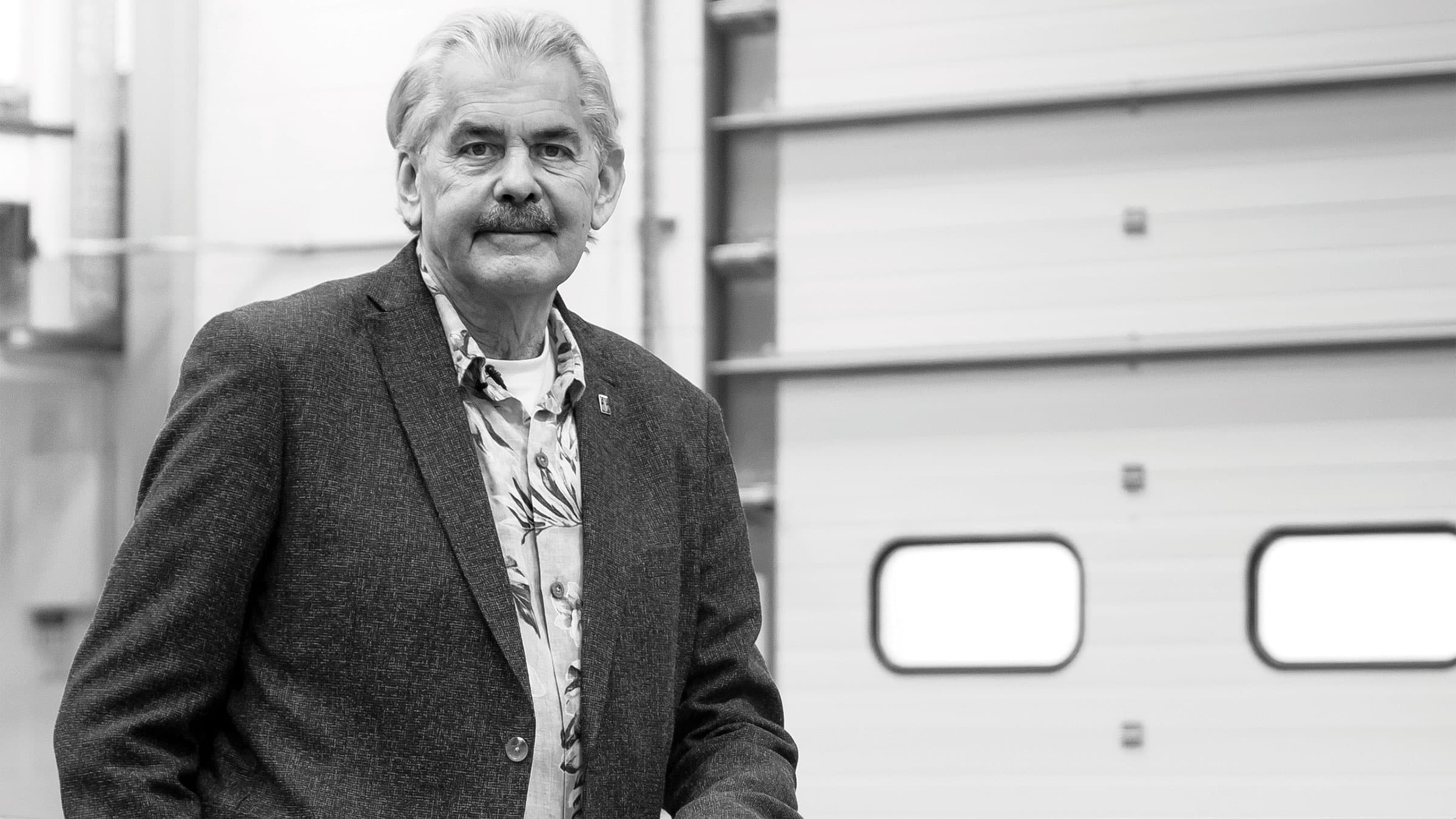 Gordon Murray stands for photo in garage