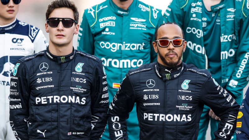 Lewis Hamilton stands next to George Russell in F1 driver group photo