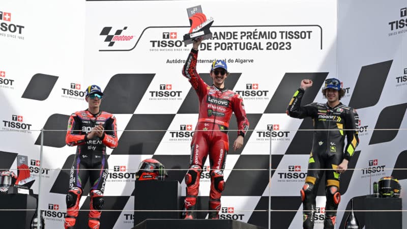 Pecco Baganaia holds winning trophy on the Portimao podium at the 2023 MotoGP Portuguese GP