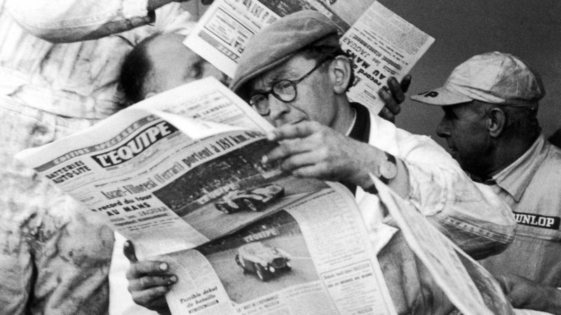 Mechanics at the 1953 race, reading newspaper reports