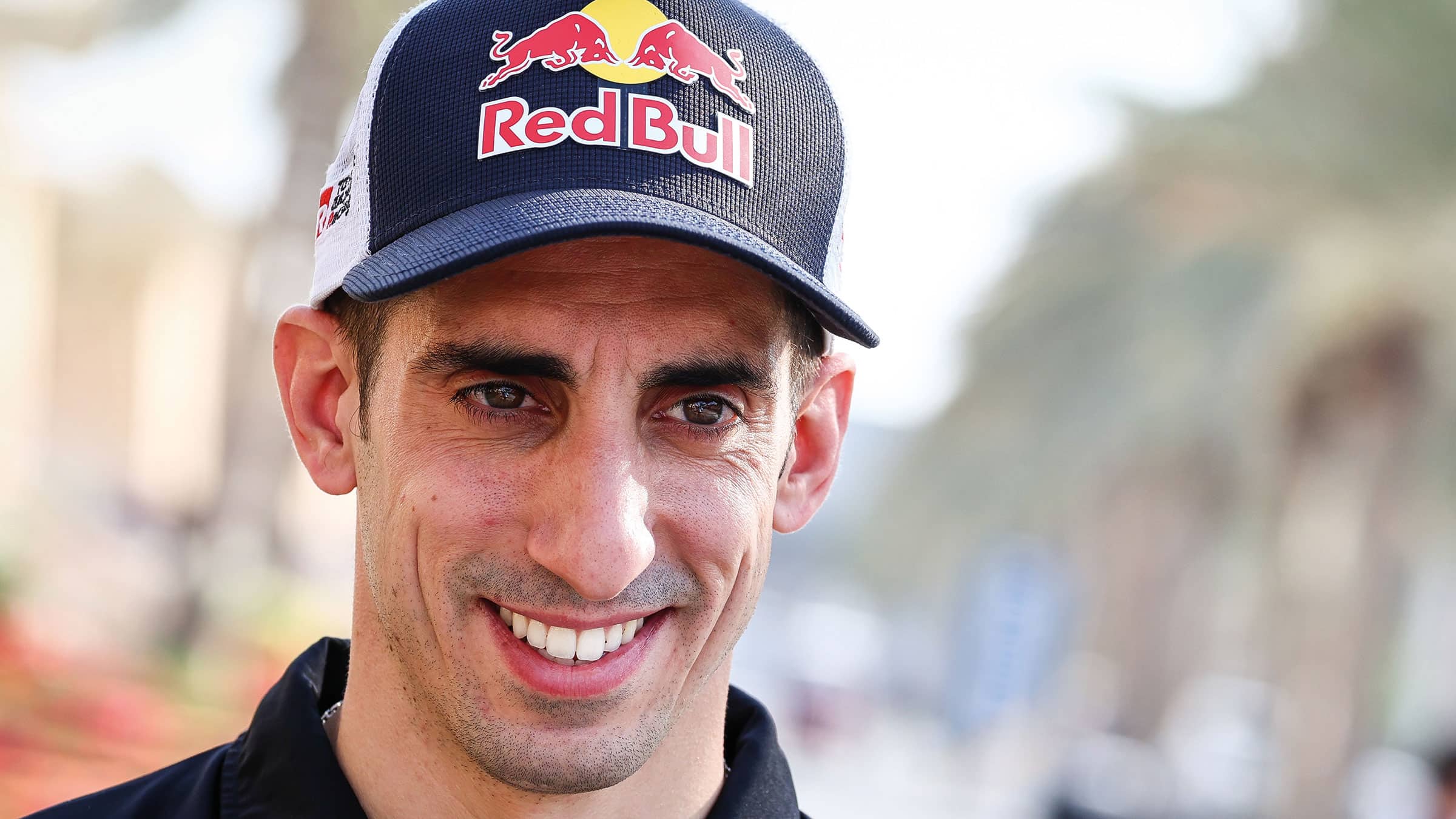 Sébastien Buemi smiling in red bull cap