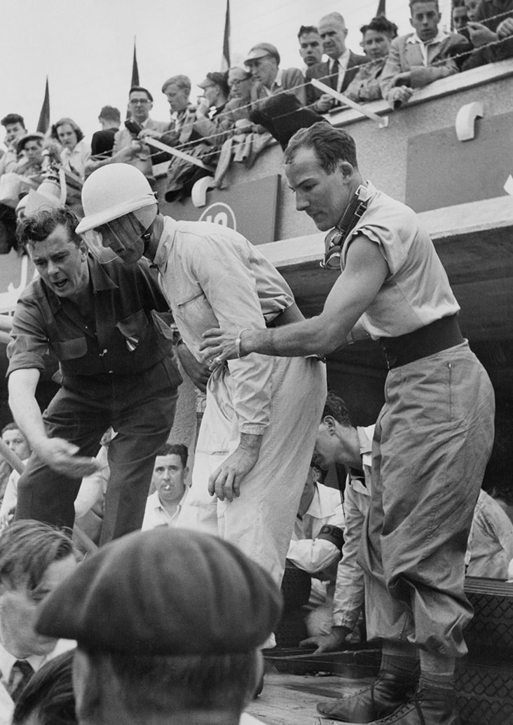 Stirling Moss and Peter Walker stand on the Le Mans pitwall in 1953