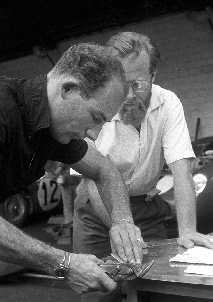 Stirling Moss cuts bodywork watched over by Denis Jenkinson at Le Mans in 1957
