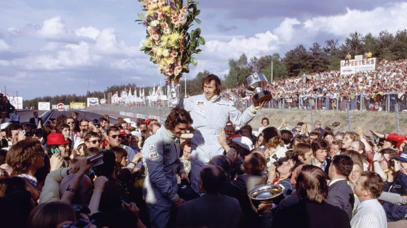 Jackie Stewart holds a bunch of flowers at Zolder