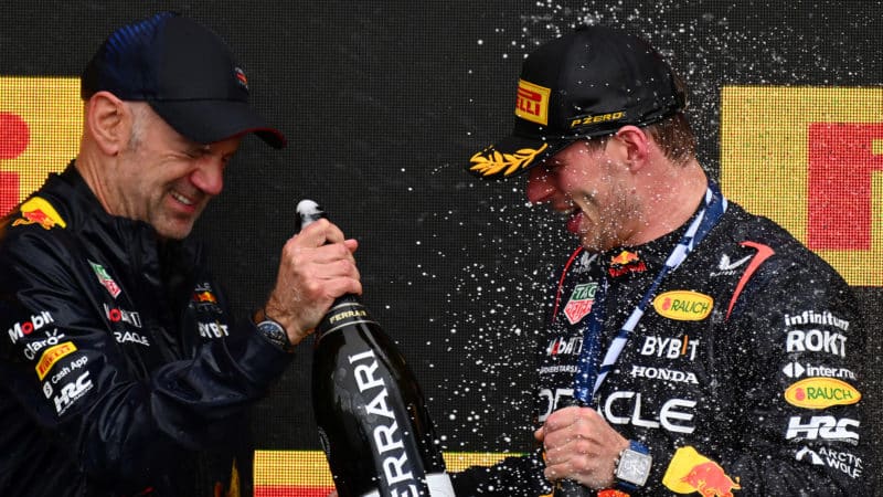 Adrian Newey and Max Verstappen clink champagne bottles on 2023 Canadian GP podium