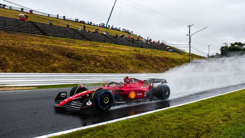 Ferrari of Carlos Sainz on wet tyres with plume of spray behind at 2022 Japanese Grand Prix