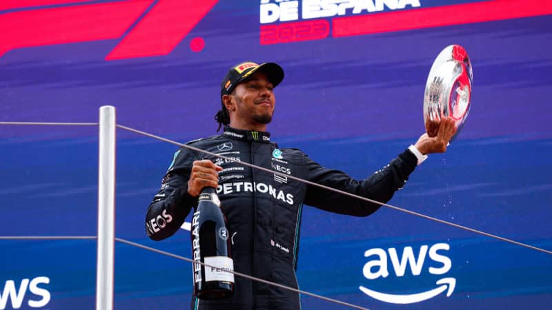 Lewis Hamilton holds up trophy on podium of 2023 Spanish GP