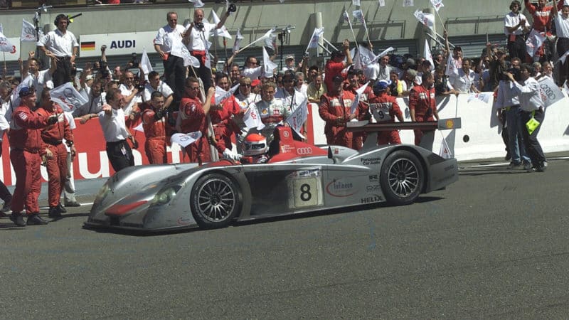 Winning Audi R8 drives past cheering team at Le Mans in 2000