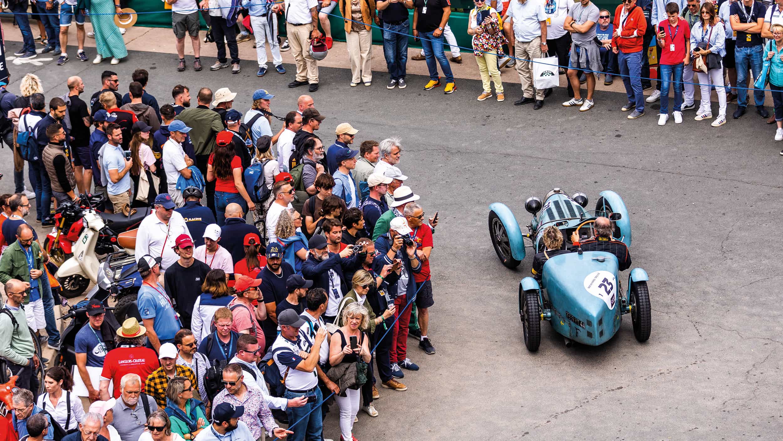 Classic car passes the croud