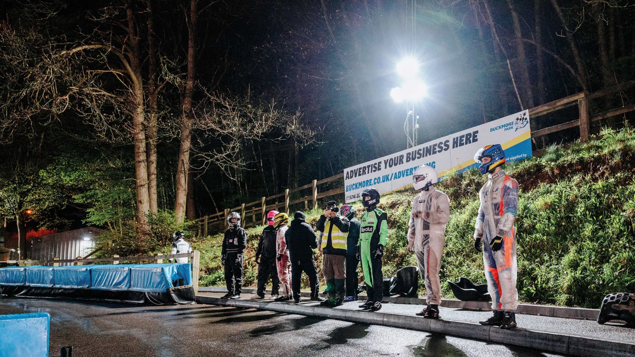 Drivers standing on track at night