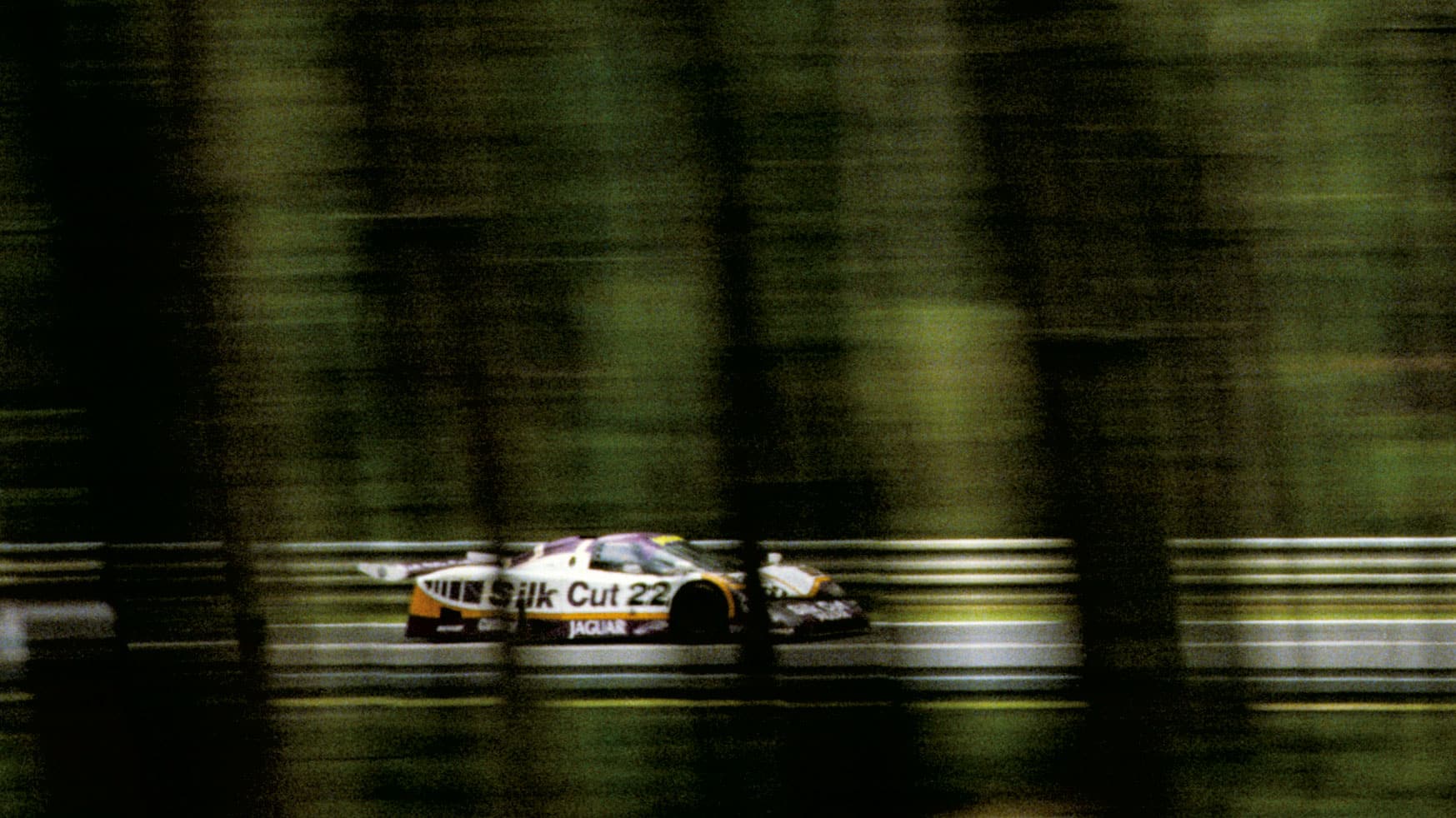 Jaguar speeding through the woods at Le Mans