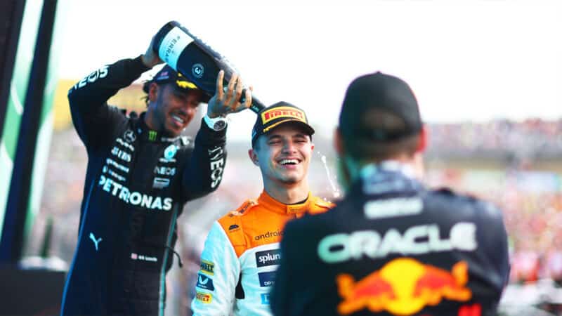 Lewis Hamilton and Max Verstappen spray Lando Norris with champagne on 2023 British Grand Prix podium