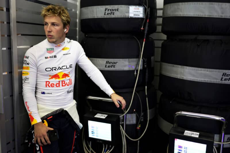 Liam Lawson next to tyre warmers in Red Bull F1 pit garage